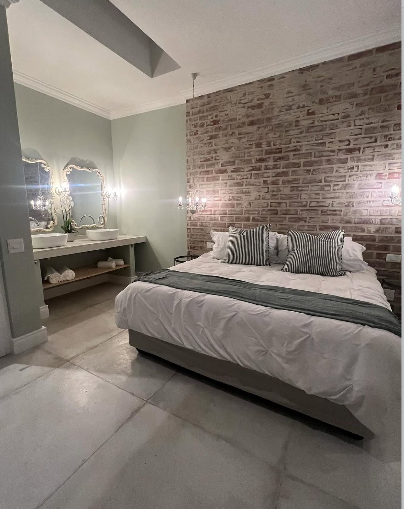King bedroom with exposed brick feature wall