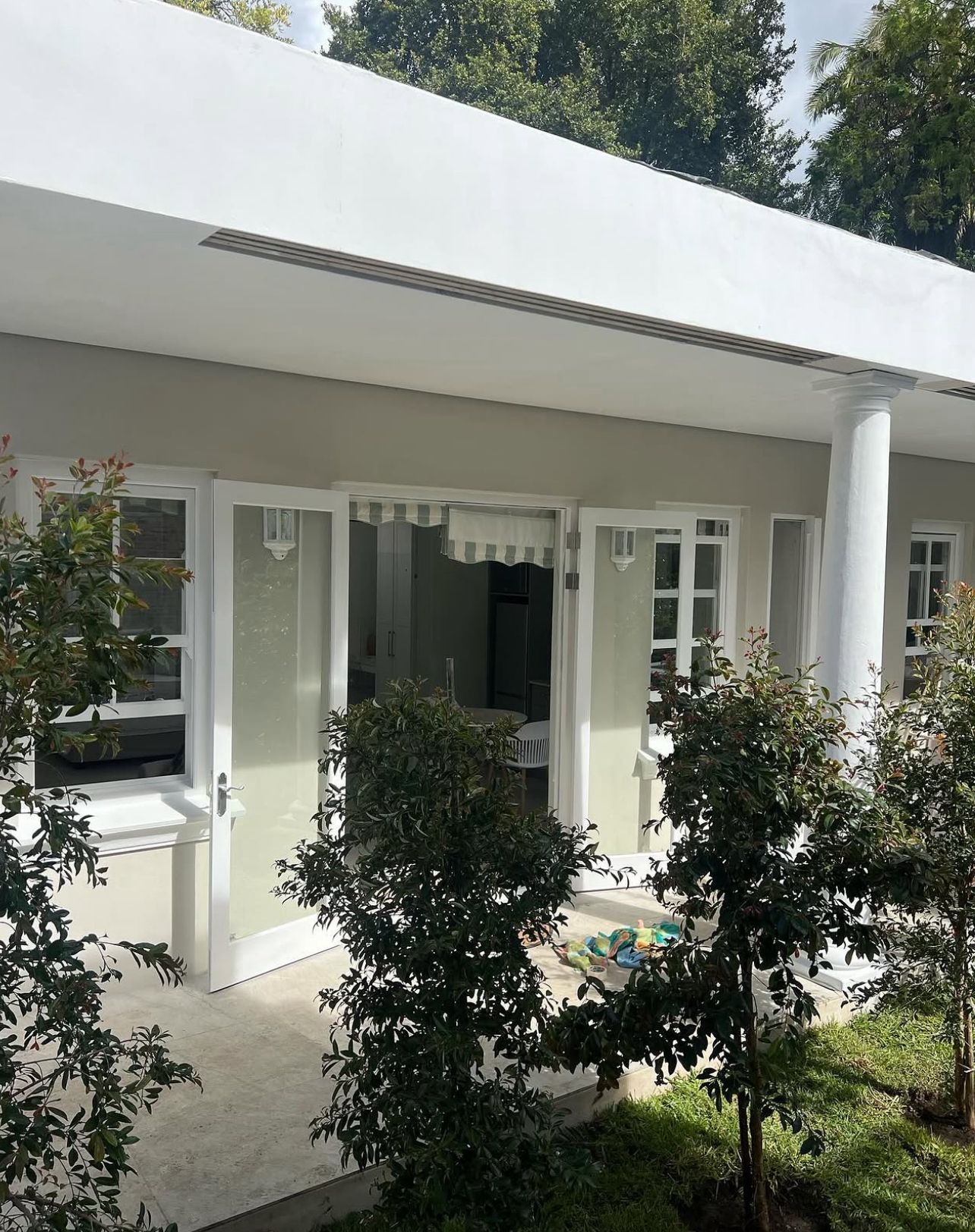 Cottage veranda framed by manicured greenery