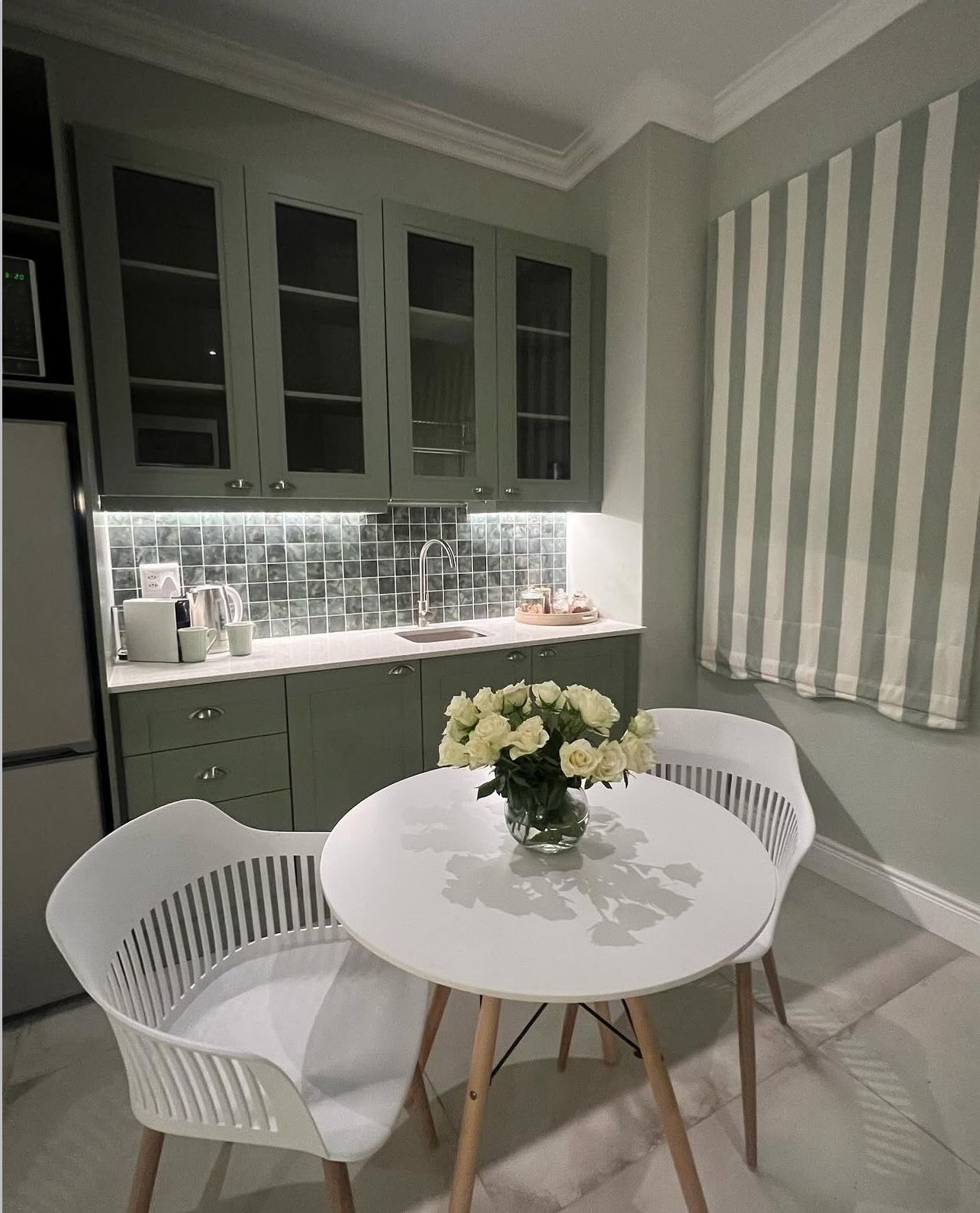 Sage kitchen with marble counters and dining nook